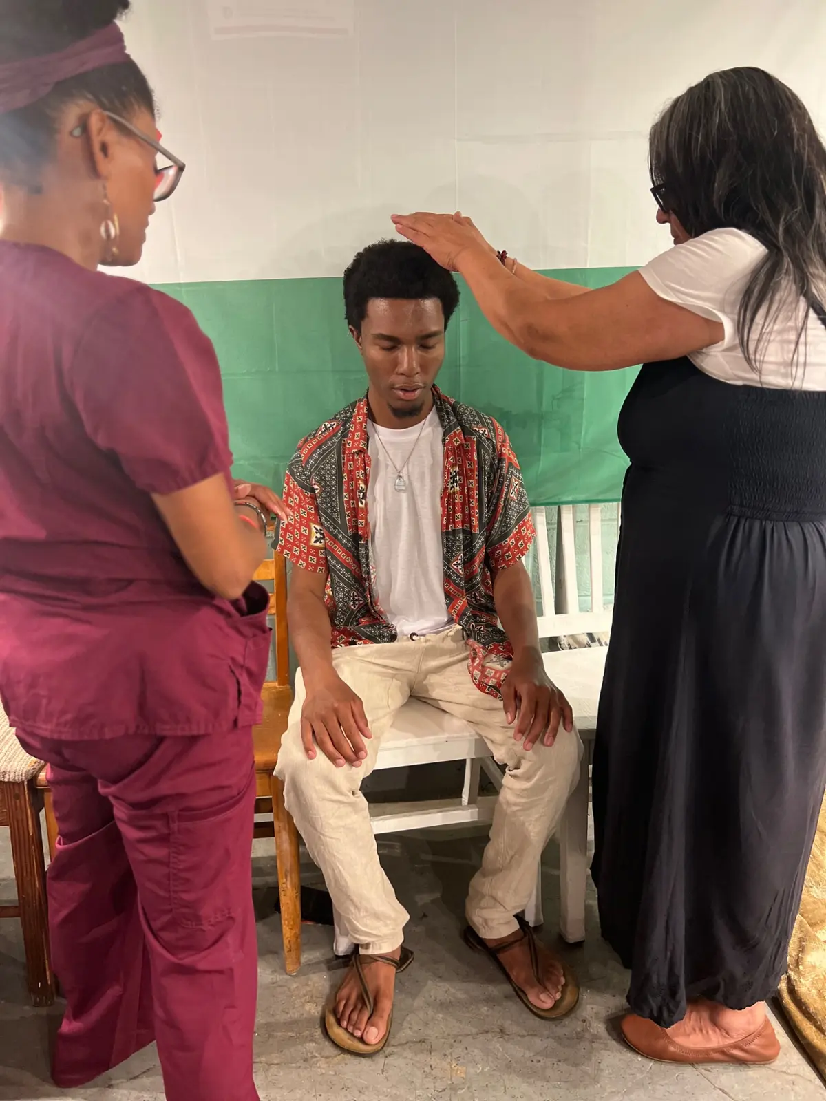 Two healers supporting a seated participant