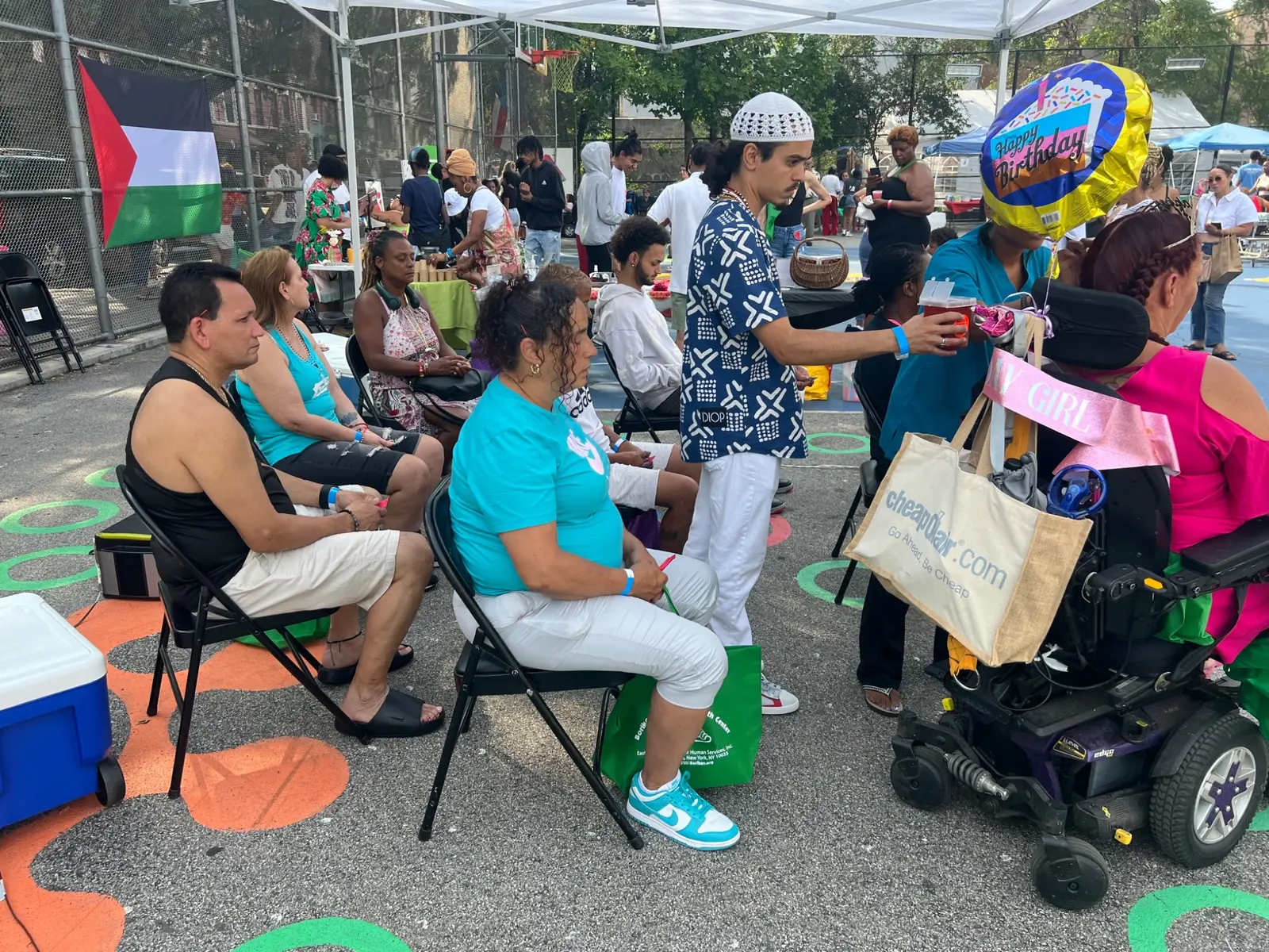 Community members gathered under a wellness tent
